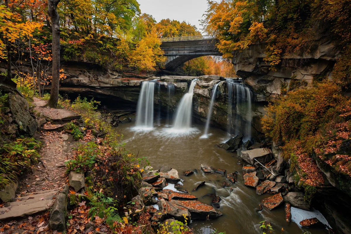 Waterfall cascading over sandstone cliffs into the Black River gorge at Cascade Park in Elyria, Ohio