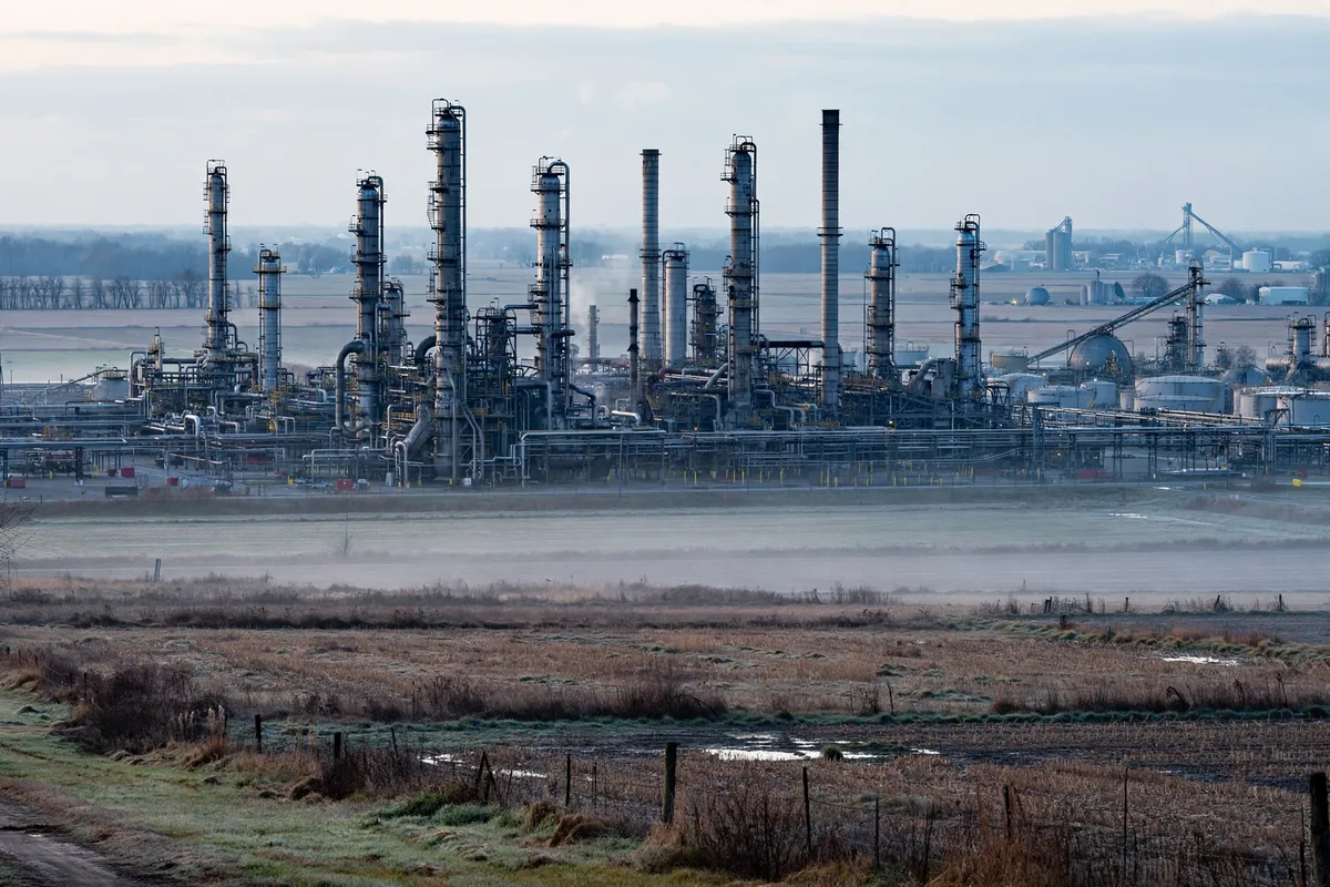 Industrial refinery towers on flat farmland at dawn south of Lima, Ohio